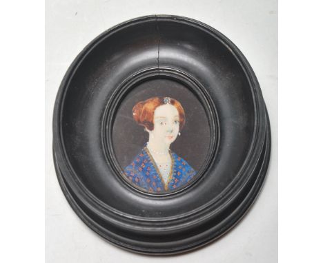 A 19th Century Victorian portrait miniature being hand painted on ivory depicting a woman wearing a blue dress with brown hai