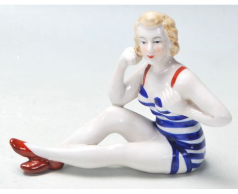 A 20th Century retro ceramic figurine of a 1940's pin up glamour model wearing a striped blue and white vintage swimming cost