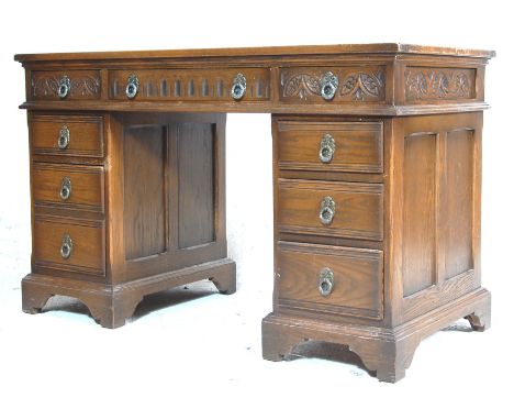 An antique style oak and red leather twin pedestal office writing desk. Raised on bracket feet with a bank of drawers to each