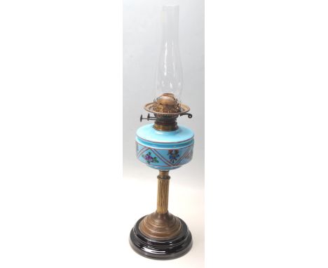 A Victorian 19th century oil lamp with a moulded and hand enamel painted blue glass reservoir decorated with flowers over a C