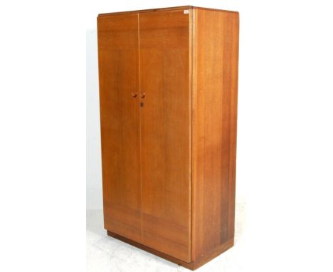 A vintage mid century light oak wardrobe by Kandya of a plain form with fitted interior raised on a plinth base with makers l