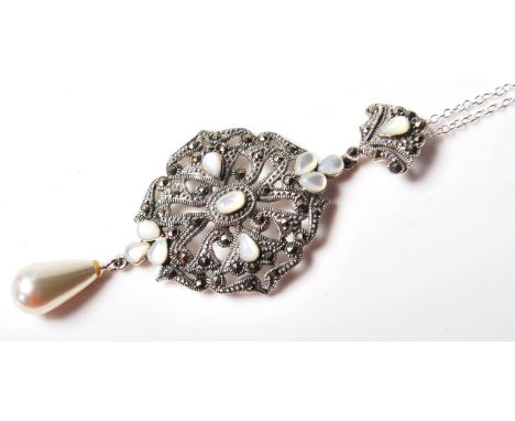 A silver renaissance style pendant necklace having a pieced arabesque design and being set with marcasites and mother of pear