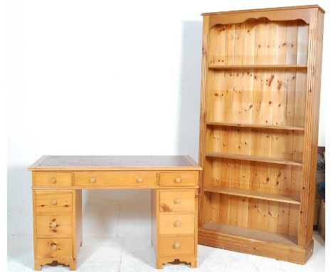 A vintage 20th century pine pedestal desk with red leather top, two banks of drawers raised on a plinth base along with a mat