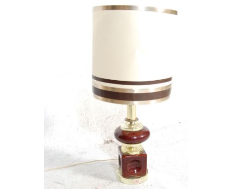 A vintage retro 1970's table lamp having a burgundy ceramic base in two cylindrical and bulbous sections with brass fittings,