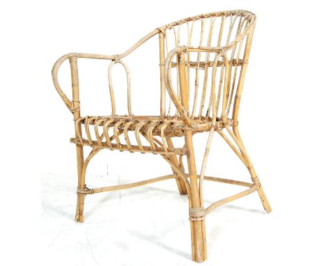 A retro vintage early 20th century bamboo tub chair having a shaped back with scroll arms set on a saddle seat over circular 