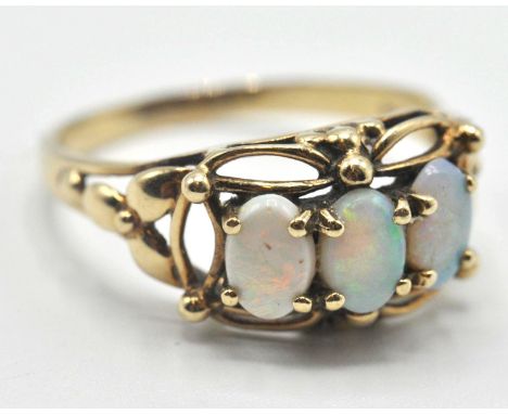 A 9ct gold ring set with three oval opal cabochons within a pierced decoration mount. Assay marked for Birmingham. Weight 2.5