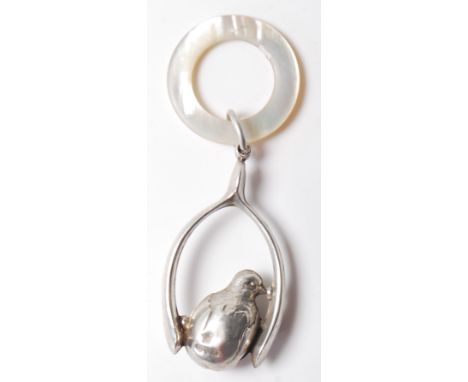 A 1919 silver hallmarked baby rattle in the form of a&nbsp;chick hatching from an egg attached to a wishbone with mother of p