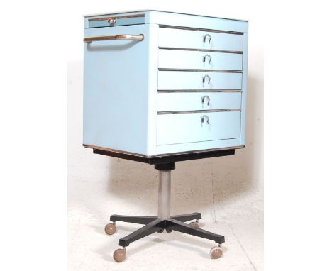 A vintage mid century metal industrial / medical dentist cabinet on stand.  The cabinet having white milk glass top flanked b