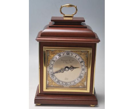 A late 20th Century vintage Garrard mantel clock. The clock having a brass and brushed steel face with cherub spandrels and R