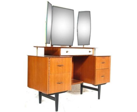 A mid century retro teak wood pedestal dressing table. Raised on tapering legs with wide body comprising a series of drawers 