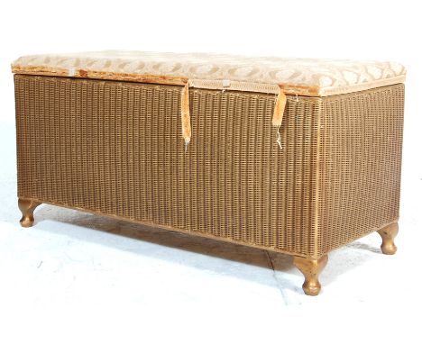 A mid century vintage Lloyd Loom " Lusty " ottoman having a gilt cushioned hinged lid opening to reveal a spacious interior t