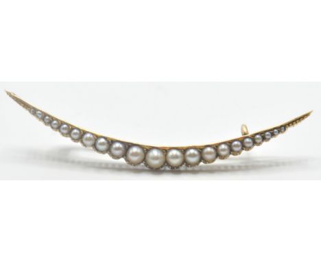 An early 20th Century gold and seed pearl brooch in the form of a crescent. The brooch set with graduating half pearls with&n