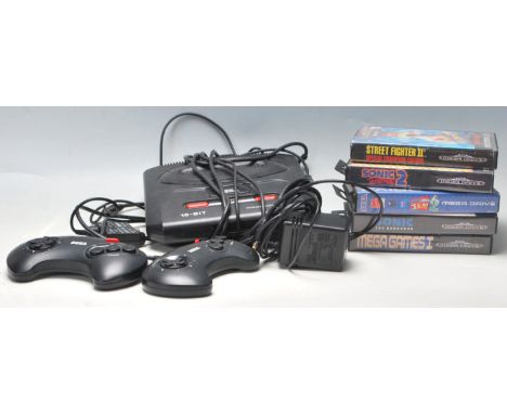 A vintage Sega Mega Drive 16-Bit video games computer console with aerial, official A/C adaptor and 2x control pads along wit