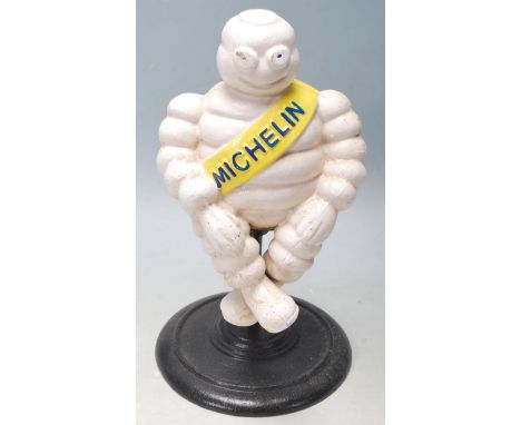 A vintage style cast iron advertising shop display point of sale figurine of the Michelin Man / Bibendum sat on a revolving s