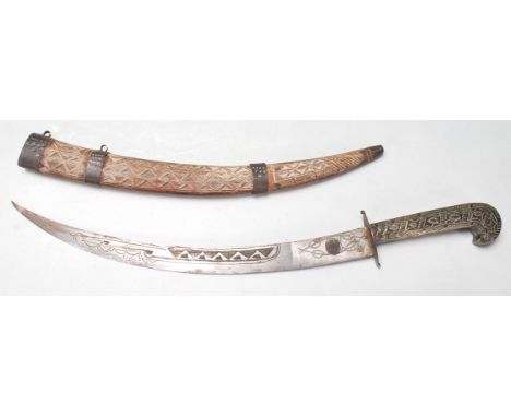 An antique early 20th century oriental / Islamic / Persian dagger having wooden scabbard decorated with geometrical carving a