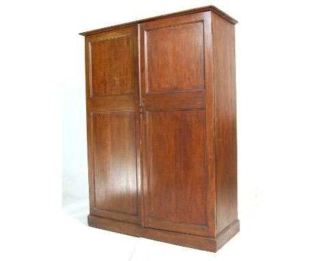 A 1920's / early 20th century oak bachelors wardrobe. Raised on bracket feet with twin full length fielded panel doors housin