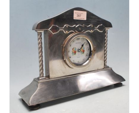 A vintage mid century white metal / chrome / silver plated mantle clock. The clock having a arched top with twisted columns, 