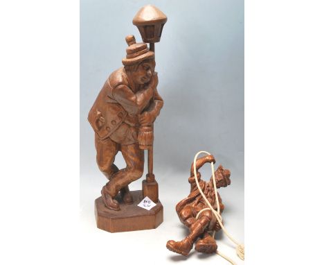 A pair of late 20th Century Black Forest German carved wooden figures depicting a mountaineer descending on a rope and a drun