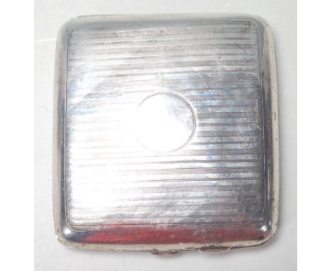 An early 20th century silver hallmarked cigarette case having engine turned decoration with a circular central panel, hinged 
