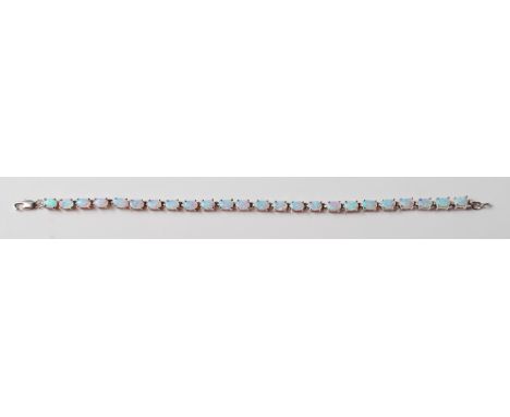 A ladies silver line bracelet prong set with oval opal stones with a lobster clasp. Marked 925. Weight 11.3g. Measures 8 inch