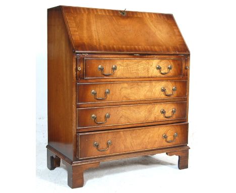 An antique style 19th century revival oak bureau having a fall front writing area opening to reveal a fully appointed interio