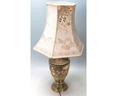A 19th Century cast brass / metal lamp base having a flared neck with raised bat motif's with cast dragon shaped handles, the