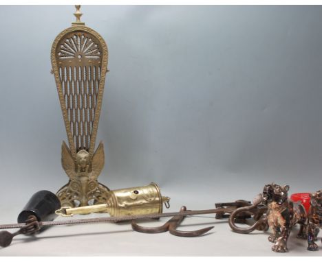 An early 20th century fret worked metamorphic peacock fire guard screen together with a cast iron and steel WT Avery &amp; Co