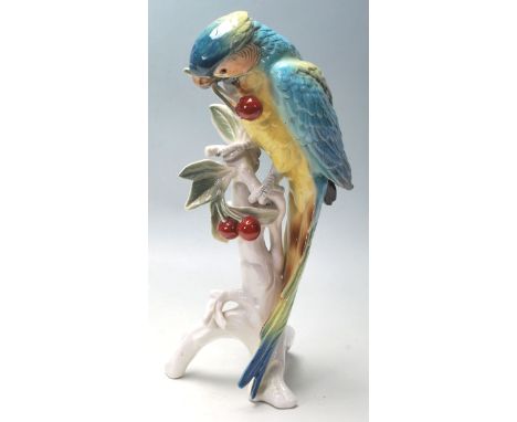 Karl Ens - A vintage 20th century porcelain ceramic&nbsp;model of a parrot perched upon a branch eating cherries on a tree st