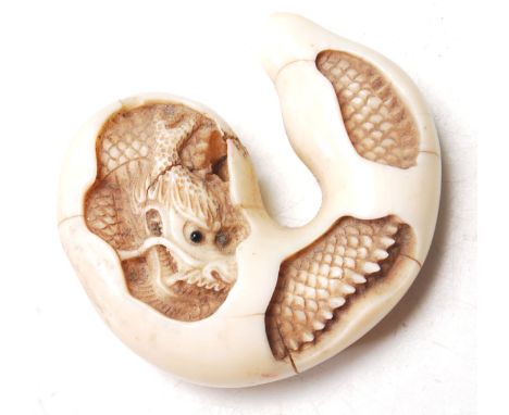 A late 19th Century Oriental Japanese finely carved ivory netsuke. The netsuke depicts a dragon hatching from an egg. Signatu