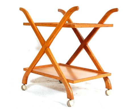 A vintage mid century oak trolley having an unusual bent cross stretchered tray atop and lower tray raised on castors. 65cm x
