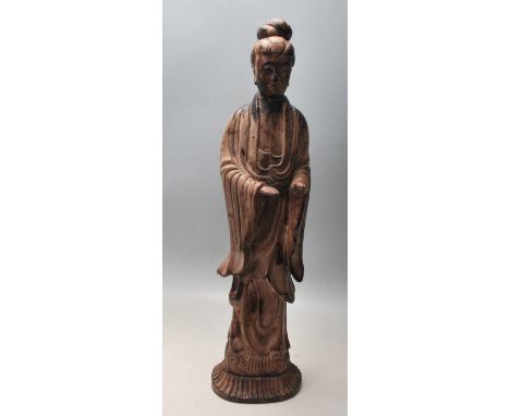 An early 20th Century Chinese oriental ceramic figurine in the form of Guan Ying, having a wooden style patina, the figure mo