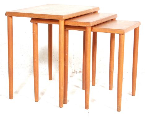 A vintage retro mid 20th Century teak wood nest of three tables having rectangular tops raised on tapering turned legs. Measu