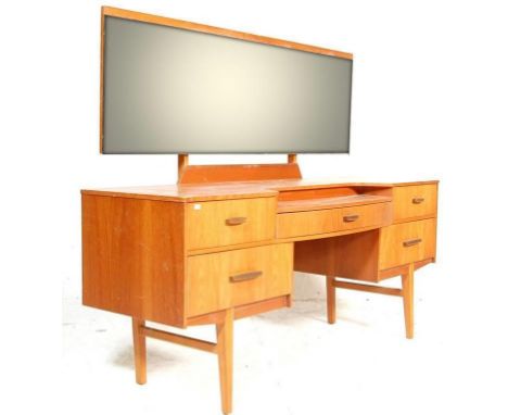 A good retro vintage 20th century teak dressing table in the manner of Mogens Kolo with drop centre, brass handles to the dra