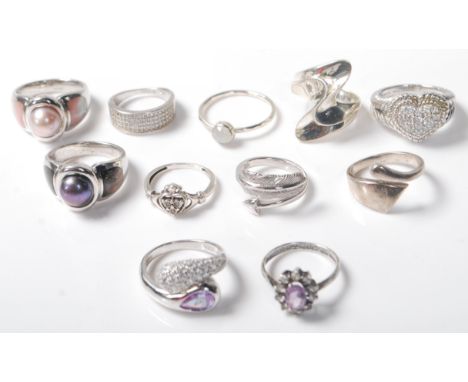A group of eleven silver ladies rings to include a ring set with a purple stone with a halo of white stones, a black pearl ri