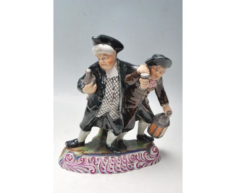 A late Victorian early 20th century Staffordshire figurine of the drunkards, one holding a bottle of alcohol and the other ho