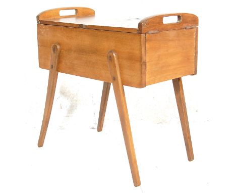A vintage retro wooden sewing box having twin pierced handles to the top with hinged lid to the top opening to reveal a secti