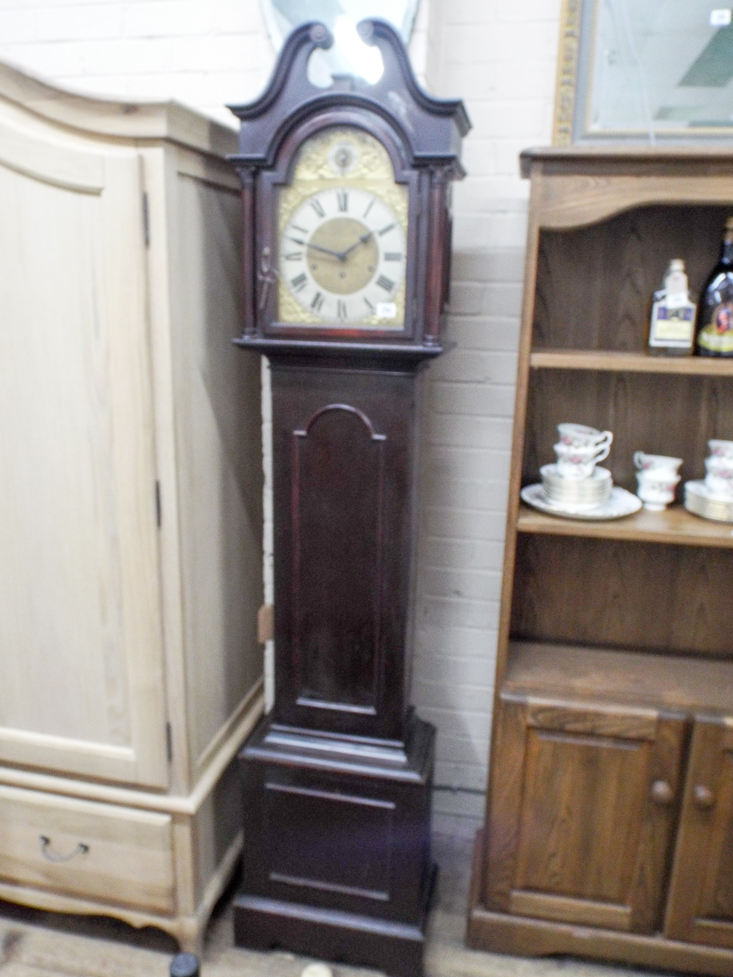 A small reproduction chiming grandfather clock with brass and silver ...