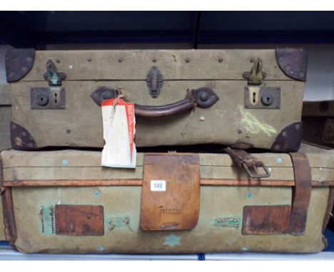 Four old canvas suitcases and one square canvas trunk
