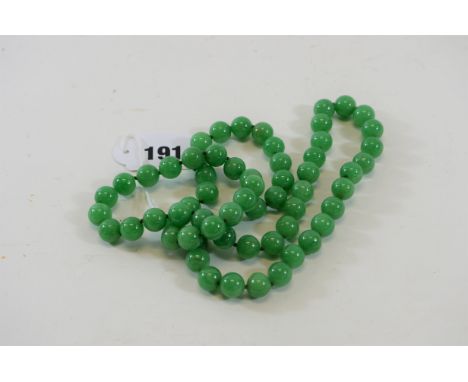 A STRING OF POLISHED APPLE GREEN JADE BEADS, 30 ins long.   £25-£40