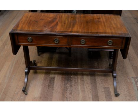 A REGENCY REVIVAL MAHOGANY SOFA TABLE, the cross banded top with end flaps, two frieze drawers raised on end supports with br