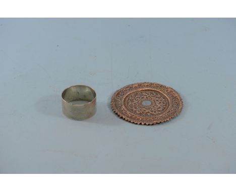 A GEORGE V CIRCULAR SILVER NAPKIN RING, maker:- T.H.H, Birmingham 1912 and an Indian foliate embossed white metal PLATE, 3 3/