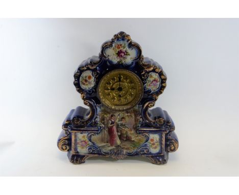 A LATE VICTORIAN TRANSFER DECORATED POTTERY CASED MANTLE CLOCK, single train movement with gilt dial, 18 ins high.   £25-£40