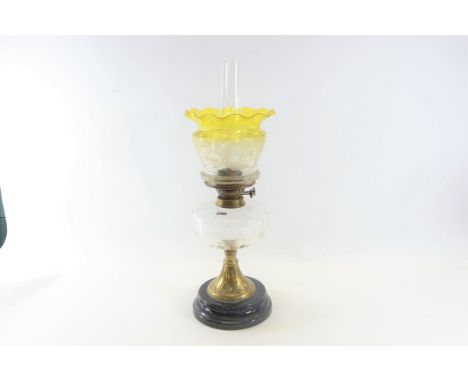 A LATE VICTORIAN TABLE OIL LAMP with clear glass fount, brass base and pottery plinth, 10 1/2 ins high together with an etche