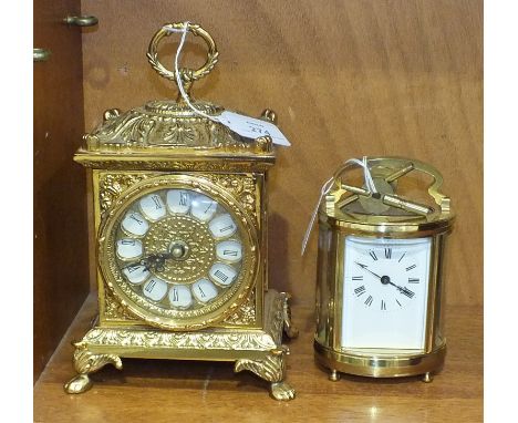 A 20th century French oval brass carriage clock, with white enamel dial escapement, (not operating) and a modern gilt brass b