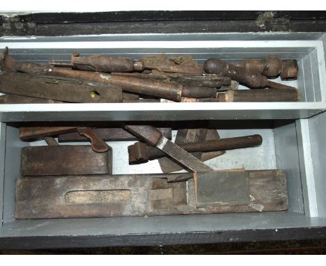 A collection of wooden planes and other tools, in three wooden tool boxes.