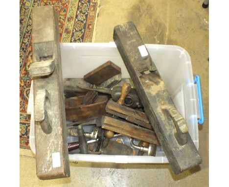 A collection of tools, including a wood plough plane, a brace and two wood-handled draw knives.