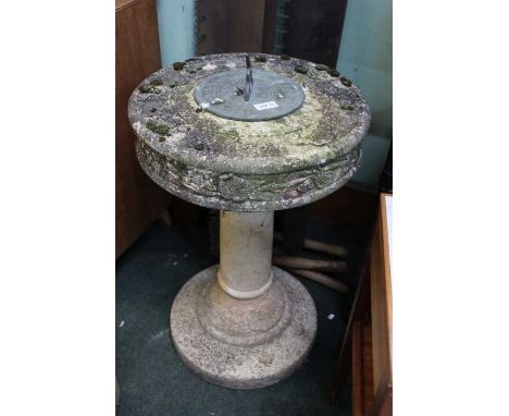 A sundial on concrete pillar.
