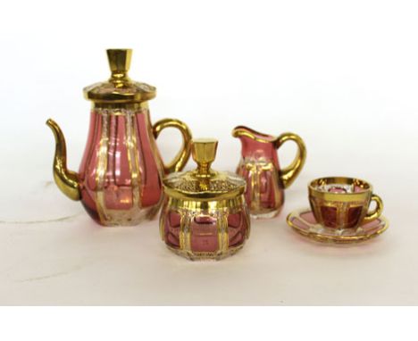 A Bohemian ruby glass decanter and stopper, h. 37 cm, an ornate six sitting glass tea service and pale red mottled glass frui