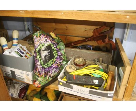 A shelf of assorted, including toy cars, tools and skittles etc.