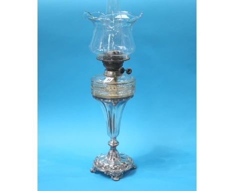 A silver plated oil lamp, with clear glass reservoir and shade